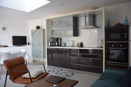 Cuisine ouverte et salon contemporain au gîte Le Fassardy à Châteauroux, avec mobilier noir et inox