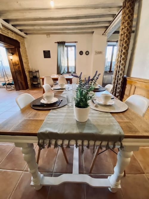 Elegantes Esszimmer im B&B La Maison de la Colline in Vers, Frankreich mit Holztisch, weißen Stühlen und Lavendelarrangement