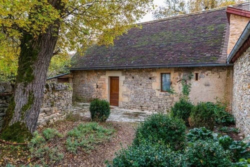 Stone cottage at Vue Sur Gindou with garden view, featuring rustic architecture and lush landscaping in Gindou, France