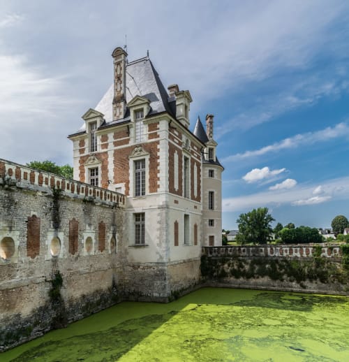 Tour historique du château avec façade en brique et pierre, entourée de douves au Domaine Des Bois Argentés, Pruniers-en-Sologne