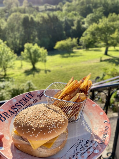Burger gastronomique et frites servis en terrasse à La Maison de la Colline, Vers, vue sur les jardins luxuriants