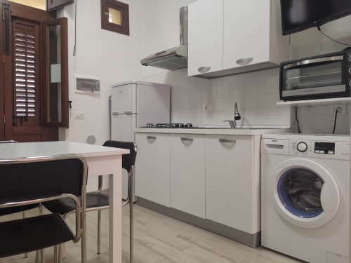 Modern equipped kitchen in Apartment Rose at Casa Vacanze Del Golfo, Castellammare del Golfo with white cabinets, appliances