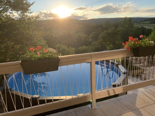 Sonnenuntergangsblick vom Balkon des Bohème-Zimmers im La Maison de la Colline, Vers Frankreich, mit Poolabdeckung und blühenden Blumenkübeln
