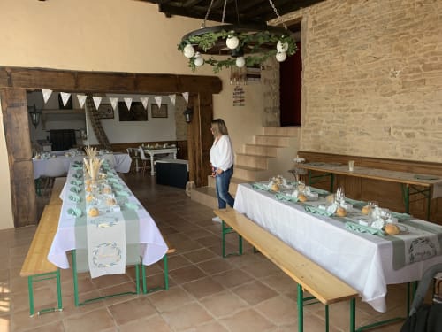 Eleganter Empfangssaal in La Maison de la Colline mit dekorierten Tischen, Blüten-Kronleuchter und Steinwänden