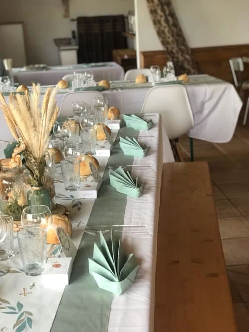 Eleganter Empfangsraum in La Maison de la Colline mit gedecktem Tisch, mintgrünen Servietten, getrockneten Blumenarrangements und Wasser