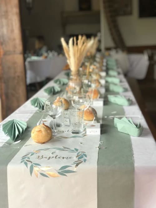 Elegante Tischdeckung im Empfangsbereich von La Maison de la Colline mit grünen Servietten, goldenen Birnen und Willkommenskarten