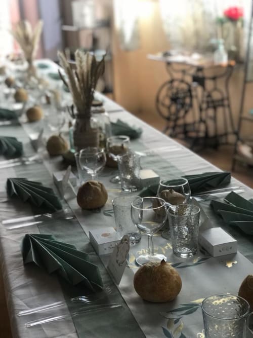 Elegante Tischdeckung im La Maison de la Colline mit grünen Servietten, Gläsern und dekorativen Elementen