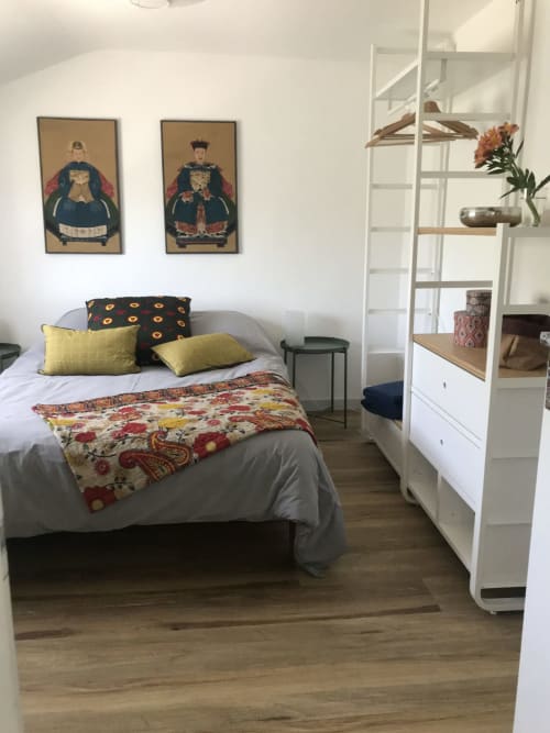 Chambre douillette aux Gîtes De L'odet avec lit, coussins jaunes et décoration murale d'inspiration asiatique à Clohars-Fouesnant