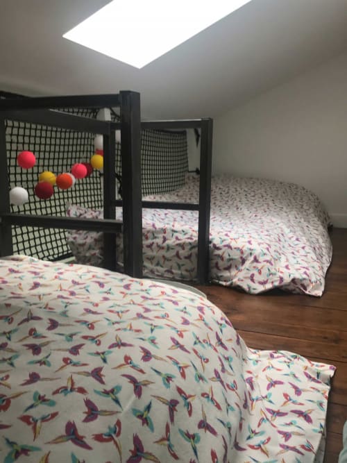 Chambre douillette aux Les Gîtes De L'odet avec literie fleurie, parc bébé noir et puits de lumière à Clohars-Fouesnant