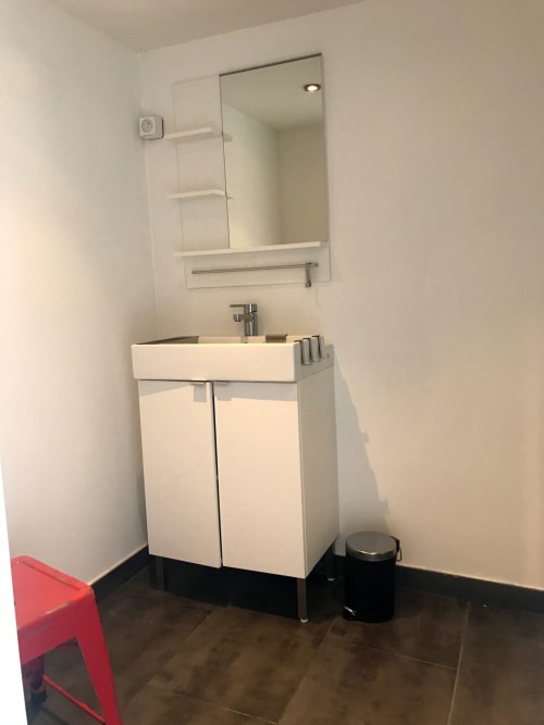 Salle de bain moderne avec vasque blanche, miroir et robinetterie aux Gîtes De L'odet à Clohars-Fouesnant