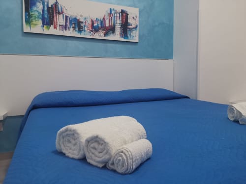 Letto blu con asciugamani bianchi arrotolati nell'Apartment Sea di Casa Vacanze Del Golfo, Castellammare del Golfo