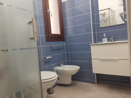 Modern bathroom in Apartment Sea at Casa Vacanze Del Golfo, Castellammare del Golfo, featuring blue tile walls, white sink,
