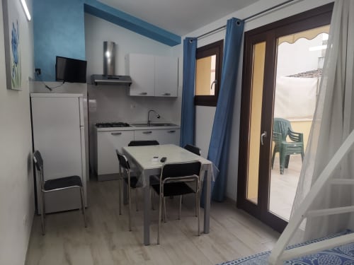 Apartment Sea kitchen and dining area at Casa Vacanze Del Golfo with dining table, stove, refrigerator and terrace access