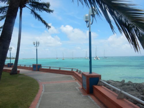 Promenade balnéaire de Caribgites à Sainte-Anne, Guadeloupe avec eaux turquoise et voiliers