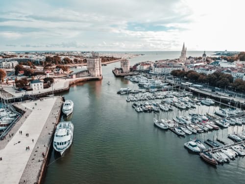 Vue panoramique du Vieux Port de La Rochelle avec ses tours historiques et voiliers, une escapade incontournable lors d'un séjour à la maison d'hôtes La Chabanaise dans le Marais Poitevin.