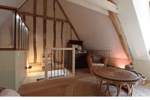 Spacieuse chambre mansardée du gîte La Dragonne à Bellême avec poutres apparentes, parquet, mobilier rotin et