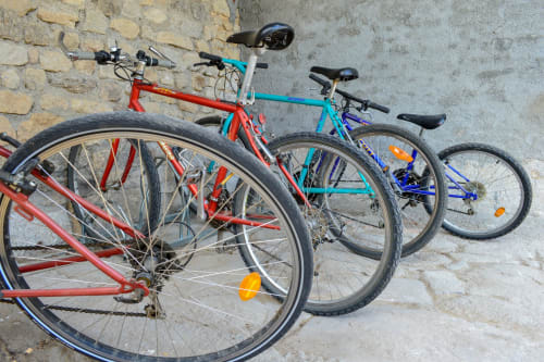 Trois vélos colorés alignés contre un mur de pierre à La Maison De Fleurat à Domeyrot, France