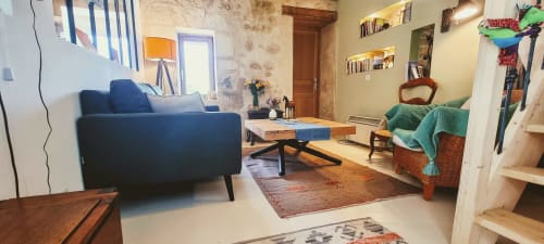 Salon chaleureux de la chambre d'hôtes La Dragonne à Bellême avec canapé bleu, table basse en bois et décoration vintage