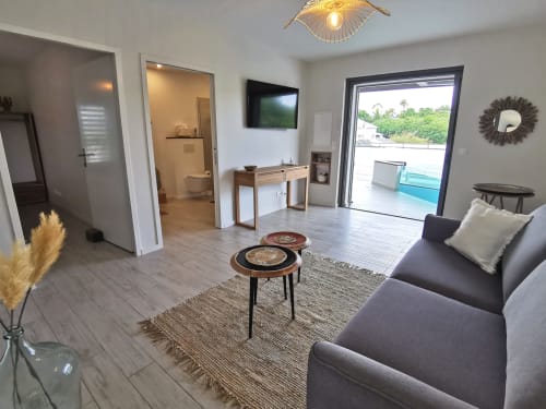 Modern studio apartment at Habitation I'SEO in Sainte-Anne with living area, kitchenette, bathroom, and pool view