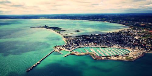 Vue aérienne du port et de la marina de Saint-Vaast-la-Hougue avec ses eaux turquoise et la ville côtière en Normandie