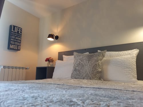 Chambre moderne à La Maison De Fleurat avec tête de lit noire, literie blanche, coussins décorifs et panneau inspirant au mur