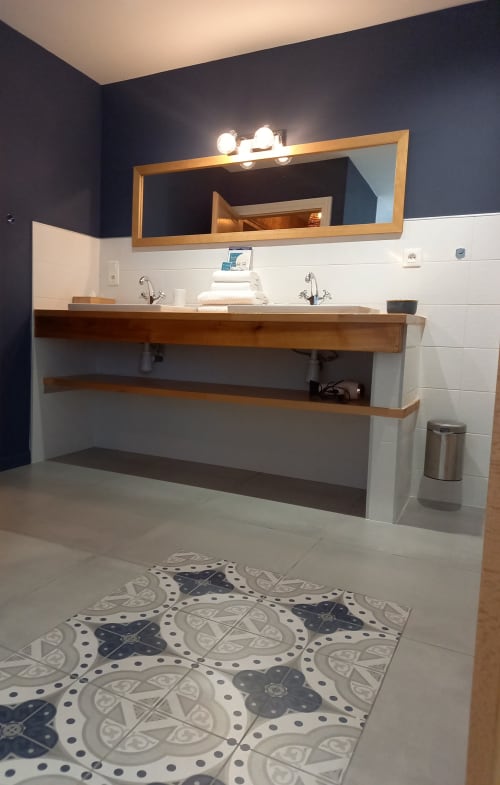 Salle de bains moderne à La Maison De Fleurat avec meuble en bois, grand miroir, double vasque et carrelage décoratif
