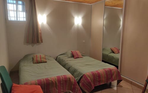 Chambre twin de l'hôtel Marjori au Lauzet-Ubaye avec armoire à miroir et vue sur les montagnes