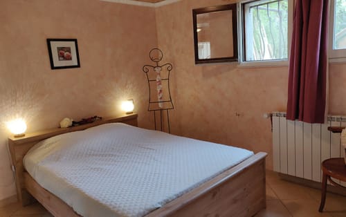 Chambre cosy à Location MarjoRI avec lit queen-size, murs pêche, art fil de fer et vue sur les montagnes