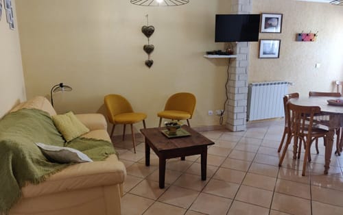 Spacieux séjour de l'hôtel Location MarjoRI au Lauzet-Ubaye avec coin salon confortable, table de salle à manger et