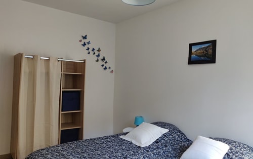 Chambre cosy de l'hôtel Marjori au Lauzet-Ubaye avec lits jumeaux, stickers papillons bleus et vue montagne
