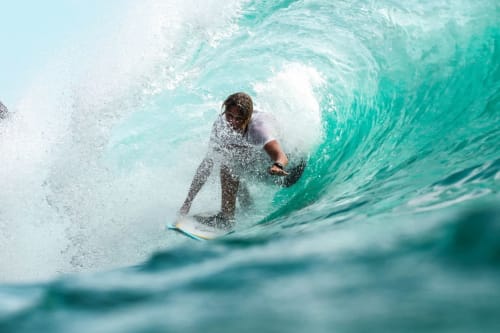 Surfista cavalgant una ona turquesa prop de l'allotjament de Queyrac, França