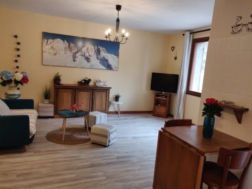 Spacieux séjour de l'appartement à Location MarjoRI avec vue sur les montagnes, mobilier en bois et murs jaunes