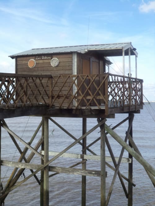Cabana elevada Le Manoir Lacustre sobre l'aigua a Queyrac, França amb baranes de fusta