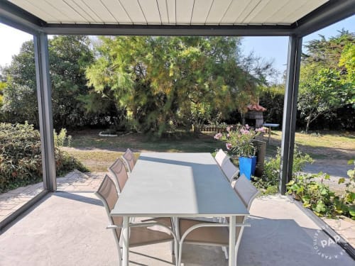 Terrasse bioclimatique de la villa L'effet Mer Parenthese à Penestín avec table à manger et vue sur le jardin