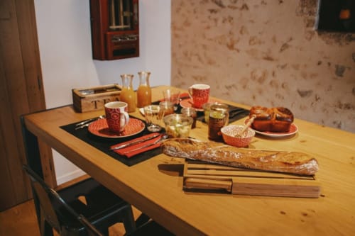 Table du petit-déjeuner aux Chambres d'hôtes Saint Jean avec pain, viennoiseries, jus, café et décor rustique à Nogent-le