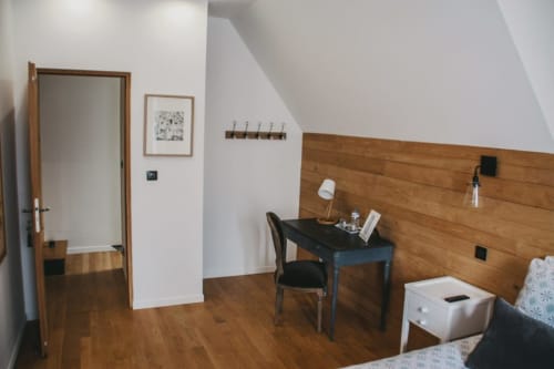 Chambre Les Ormes aux Chambres d'hôtes Saint Jean avec tête de lit en bois, bureau et vue sur la ville à Nogent le Rotrou