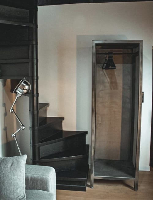 Chambre moderne aux Chambres d'hôtes Saint Jean : escalier noir, lampe articulée, chaise grise et armoire à Nogent le