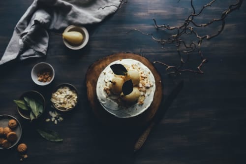 Elegante dolce guarnito di pera alle Terrasses Dorées B&B a Châtillon, circondato da noci e ingredienti