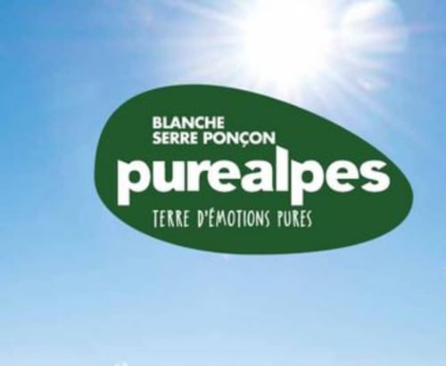 Logo Purealpes avec le slogan « Blanche Serre Ponçon - Terre d'émotions pures » sur ciel bleu