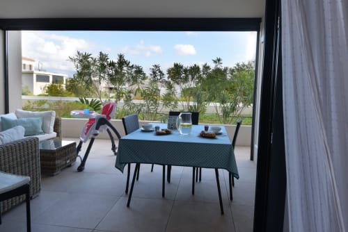 Terrasse d'appartement en Provence avec table à manger, vue sur le jardin et palmiers chez My Luxury Home