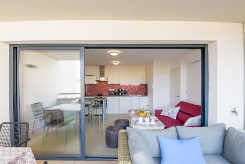 Appartement Ô de Mer C à La Cadière d'Azur avec salon canapé gris, cuisine ouverte dosseret rouge