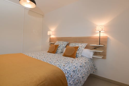 Chambre moderne de l'appartement Ô de Mer C, La Cadière d'Azur Provence, avec tête de lit en bois, literie à motifs et ambiance apaisante