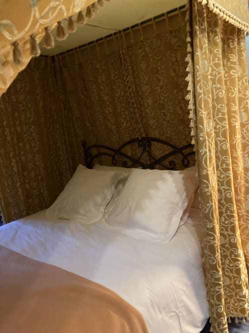 Chambre d'Aliénor d'Aquitaine au Château de Ré avec lit à baldaquin élégant et rideaux en damas
