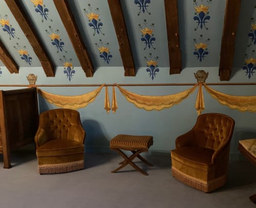 Chambre élégante d'Aliénor d'Aquitaine au Château de Ré avec mobilier d'époque, plafond aux ornements raffinés et draperies dorées