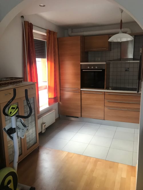 Modern kitchen with wooden cabinetry, stainless steel appliances, and tiled flooring in Giustina Apartment, Gargazzone