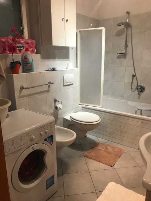 Modern bathroom in Giustina Apartment, Gargazzone with toilet, shower, vanity, and washing machine