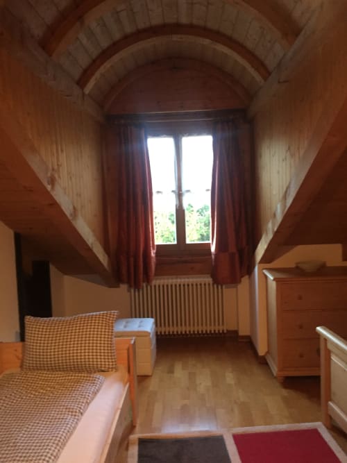 Attic bedroom at Appartamento Giustina in Gargazzone with arched ceiling, wooden furnishings, and mountain views