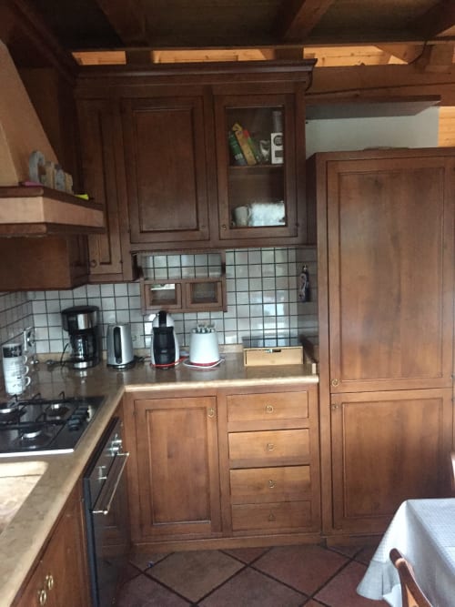 Cozy wooden kitchen in Appartamento Giustina attic apartment with gas stove, cabinets, and appliances