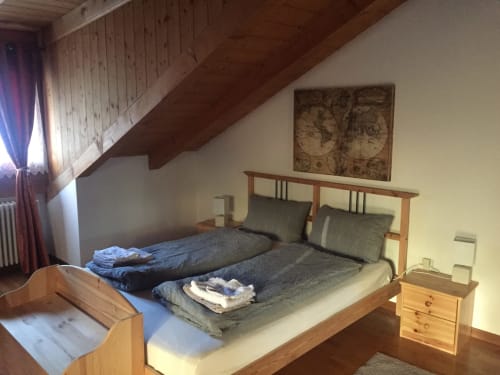 Cozy attic bedroom at Appartamento Giustina with twin beds, wooden furniture, and mountain views in Gargazzone