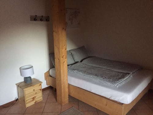 Cozy attic bedroom at Appartamento Giustina in Gargazzone with wooden bed frame and nightstand lamp